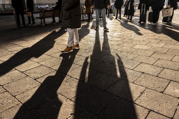 Passers-by on a sidewalk on Grunerstraße, near Alexander Platz, bus stop, in Berlin, shade, low sun, winter, Germany