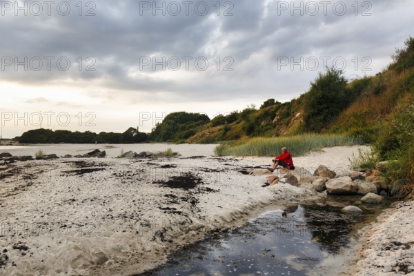 Typical coastline, Galløkken sandy beach, hiker enjoying twilight on cliffs, Rønne, Rönne, Bornholm, Baltic Sea, Denmark