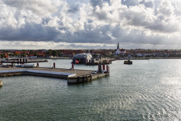Ferry terminal, harbor with cityscape, St. Nicholas Church, dramatic cloudy sky, sunbeams, Rønne, Bornholm, Baltic Sea, Denmark