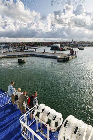 Tourists on the ferry to Rügen, ferry terminal, harbor with cityscape, St. Nicholas Church, dramatic cloudy sky, sunshine, Rønne, Rönne, Bornholm, Baltic Sea, Denmark