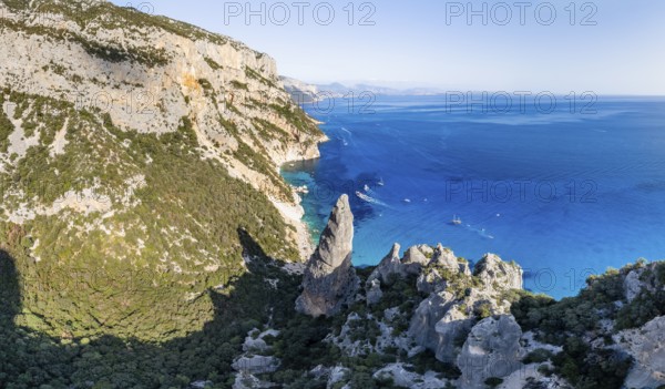 Picturesque rocky coast, cliffs with L'Aguglia pinnacle, blue sea and Cala Goloritzé beach, aerial view, Golfo di Orosei, Baunei, Sardinia, Italy