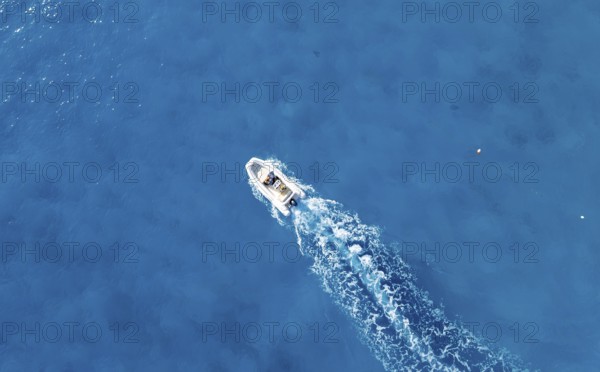 Motor boat riding on blue sea, top-down, aerial view, Golfo di Orosei, Baunei, Sardinia, Italy
