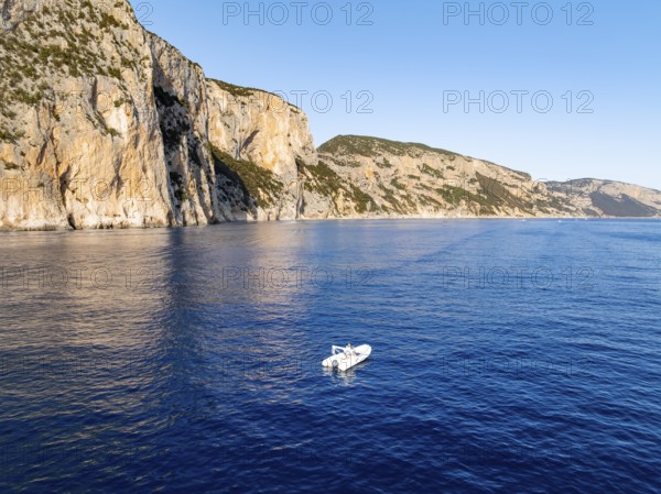 Motorboat off picturesque rocky coast ImmorgenLicht, cliffs, Golfo di Orosei, Baunei, Sardinia, Italy