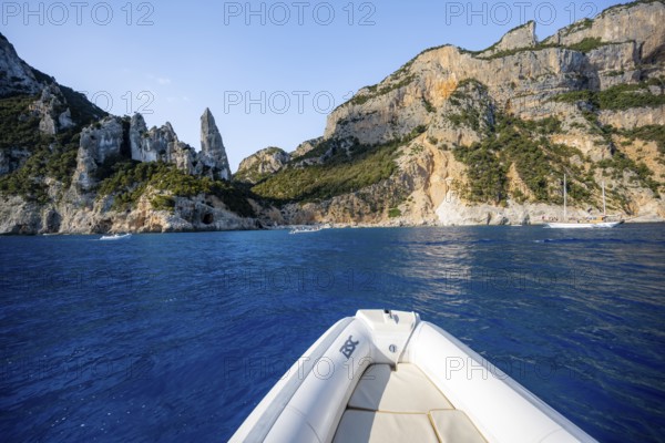 Motorboat trip along the picturesque rocky coast, cliffs with L'Aguglia pinnacle, blue sea and Cala Goloritzé beach, Golfo di Orosei, Baunei, Sardinia, Italy
