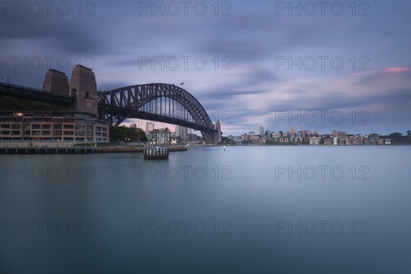 The Sydney Harbour Bridge and Kirribilli at late twilight, soft transition period, long-term view of the illuminated harbor. New South Wales, Australia