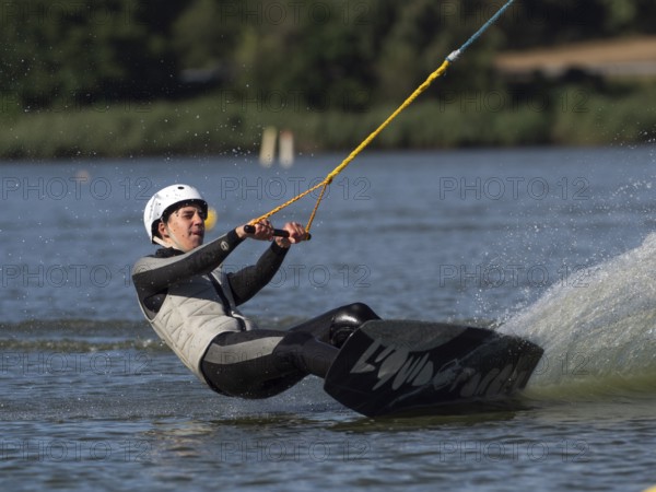 Young man with wakeboard, sporty on water, athletic model, active water sports, wake park