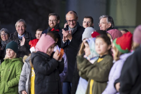Friedrich Merz (CDU, Federal Chancellor of the Federal Republic of Germany) behind the Vocal Hero Children's Choir from Schöneberg elementary schools handing over the Christmas tree to the Federal Chancellery, Berlin, 28.11.2025