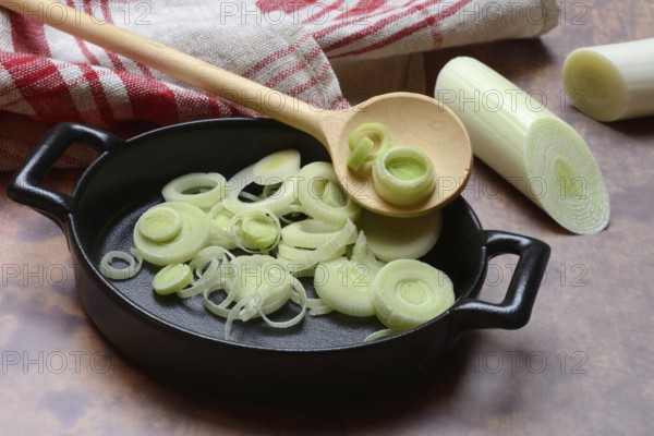 Leeks, leek rings in pan with cooking spoon, leek