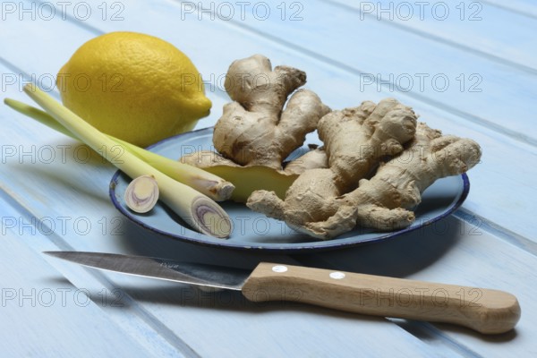Ginger tubers with lemongrass on plate, lemon