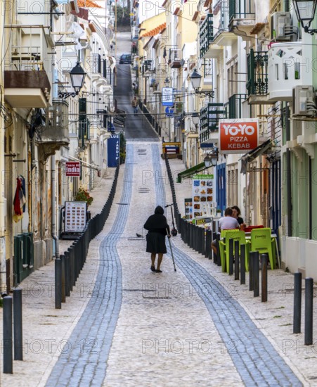 Sticker-covered sign with bicycles and surfboards, Nazaré, Portugal