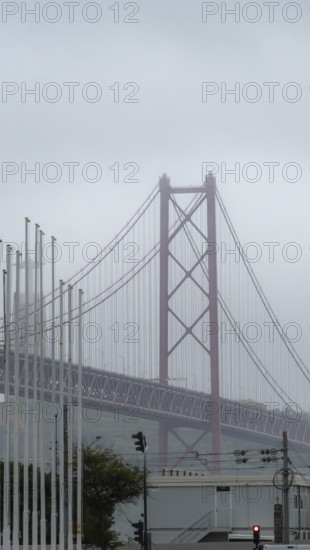 The Ponte 25 de Abril, 3.2 km long bridge in Portugal with a 2278 meter long suspension bridge across the Tagus, cloudy and rainy weather, third-longest suspension bridge with combined road and rail traffic, Lisbon, Portugal