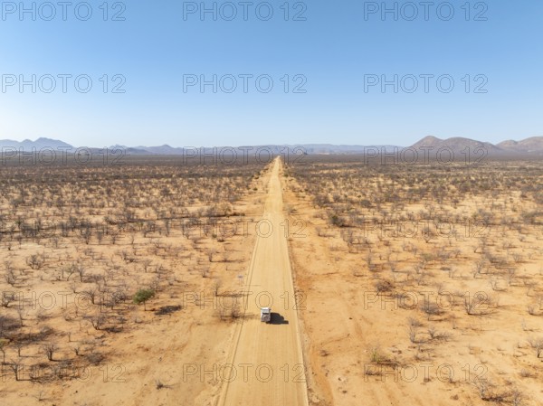 Travel, aerial view, car driving on road through arid landscape, Kunene region, Namibia