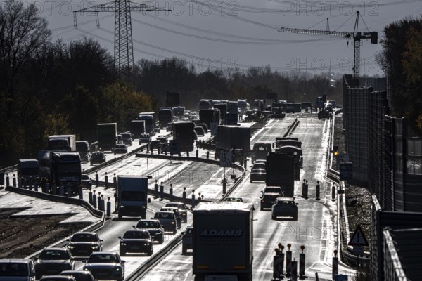 Highway construction site, the A57 is extended to 6 lanes on the section between the Meerbusch motorway junction and the Oppum junction, traffic runs parallel to 2 narrowed lanes, wet road after rain shower, Krefeld, North Rhine-Westphalia, Germany