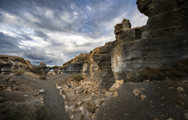 Eroded rock formations, volcanic landscape with dramatic cloudy skies, Ciudad Estratificada or Los Roferos, Antigua Rofera de Teseguite, Lanzarote, Canary Islands, Spain