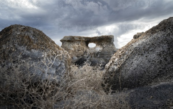 Eroded rock formations with rock tunnels, volcanic landscape with dramatic cloudy skies, Ciudad Estratificada or Los Roferos, Antigua Rofera de Teseguite, Lanzarote, Canary Islands, Spain