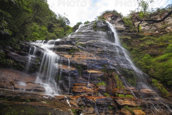 Leura Falls in a lush valley full of ferns and vegetation, Blue Mountains, New South Wales, Australia