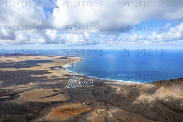 View from the Risco de Famara cliffs to the coast and the sea with the Famara beach, Playa de Famara, Lanzarote, Canary Islands, Spain
