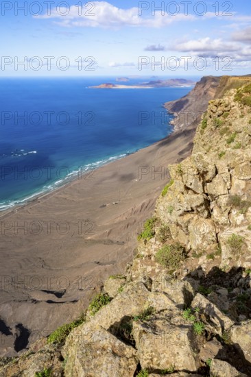 Castillejo viewpoint, view from the Risco de Famara cliffs to the coast and the sea with the Famara beach, Playa de Famara, Lanzarote, Canary Islands, Spain