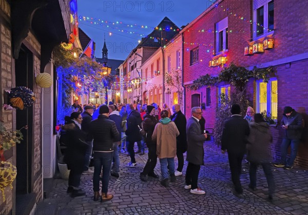 People in the Tiefstraße decorated for the Martin train in the evening, historic old town, Kempen, Lower Rhine, North Rhine-Westphalia, Germany