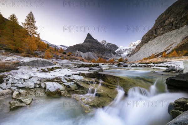 Mountain stream with autumnal larches and mountain views, Mont Mine, Ferpecle glacier, Val d'Herens, Canton of Valais, Switzerland