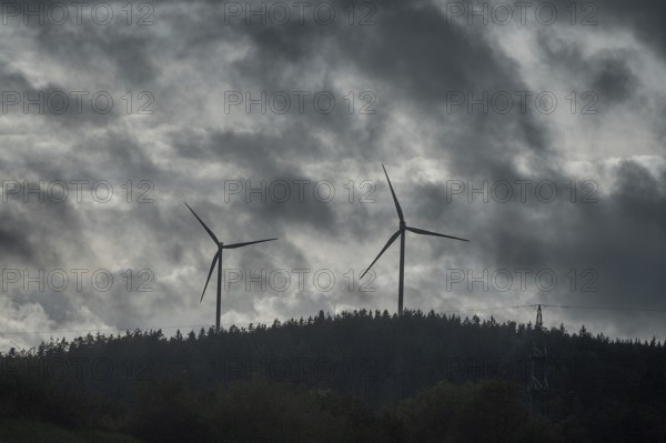 Wind turbines in pine forest during thunderstorm, Bavarian Forest, Bavaria, Germany