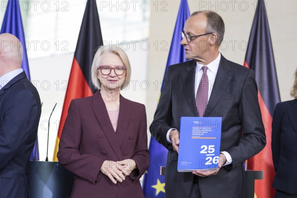 Prof. Dr. Monika Schnitzer (Chair of the Council of Experts) and Friedrich Merz (Federal Chancellor of the Federal Republic of Germany, CDU) handing over the 2025/2026 annual report entitled Creating prospects for tomorrow - do not squander opportunities from the Council of Experts to review macroeconomic development in the Federal Chancellery on 12.11.2025