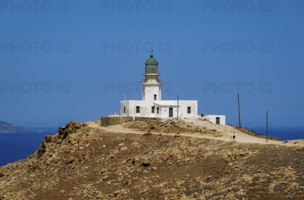 Mykonos, Cyclades, Greece - The Armenistis lighthouse in the north of the island is a landmark and a popular destination for tourists. In the back is the island of Tinos