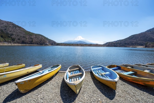 Rowing boats on shore, view across the lake to Mt Fuji volcano, Motosu Lake, Yamanashi Prefecture, Japan