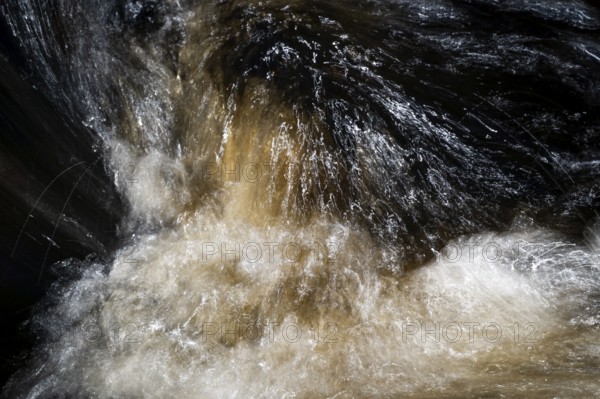 Stream flow with dark water, reflections and turbulences, long exposure, Sweden