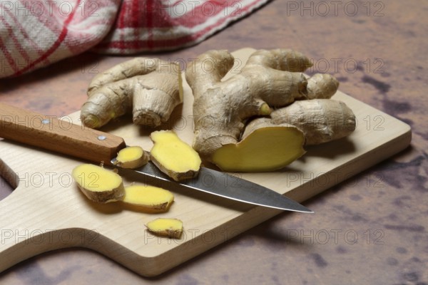 Ginger, ginger root cut with ginger slices on wooden boards