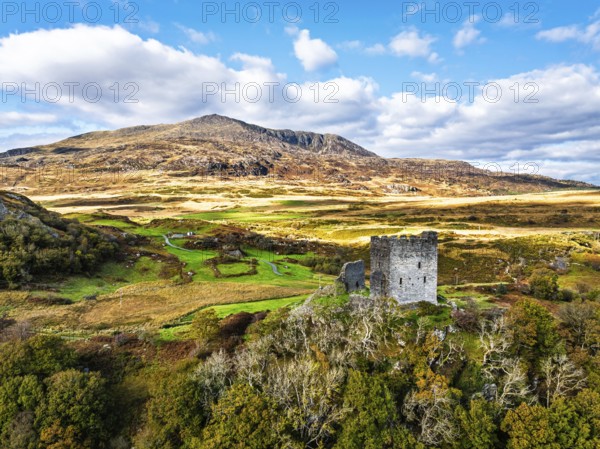 Autumn colours over Castell Dolwyddelan and Eryri Mountains from a drone, Snowdonia, Conwy County Borough, Wales, England, United Kingdom