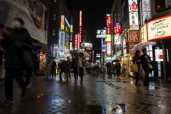 Busy pedestrian zone with many shopping centers and stores, illuminated with lots of neon signs at night, Shibuya, Udagawacho, Tokyo, Japan