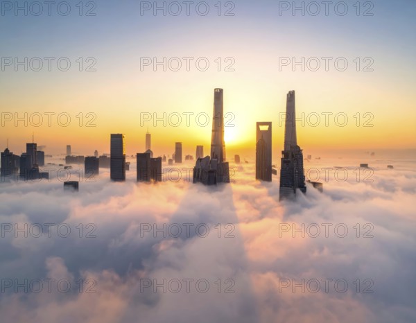 City scape emerging from a dense enveloping fog in sunrise and skyscrapers piercing the haze, big metropolis with skyline, mist on ground, blue sky, city in an aerial view, AI generated