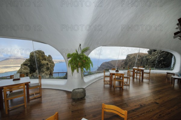 Interior of café with panoramic window in building designed by Cesar Manrique with the collaboration of Jesús Soto and architect Eduardo Caceres without right angles corners on viewpoint tourist attraction El Mirador del Río on the summit of the 474 meter high Risco de Famara in Famaramassiv with panoramic view of the Chinijo Archipelago, La Graciosa island, Lanzarote, Canary Islands, Canary Islands, Spain