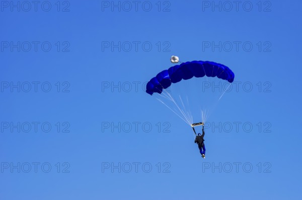 Skydivers during an aerial acrobatic performance as part of an air show at the Fliegerbergfest of the Rossfeld Luftsportverein in Metzingen-Glems, Baden-Württemberg, Germany, for editorial use only
