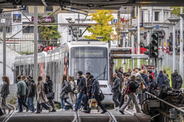 Pedestrians cross the tram tracks, at Düsseldorf-Bilk station, junction of S-Bahn, subway, tram, local bus transport, North Rhine-Westphalia
