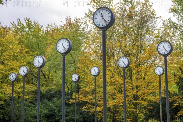 The art installation Zeitfeld in Volksgarten Park in Düsseldorf-Oberbilk, a total of 24 station clocks, on 6 meter high steel columns, have been running synchronously since 1987, artwork by Düsseldorf artist Klaus Rinke, symbol of time, time change, North Rhine-Westphalia, Germany