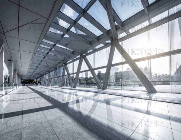 Modern architectural framework with glass and steel structure, glass facade with a greed of steel arrows, blue sky with a soft golden light of a sunrise, AI generated