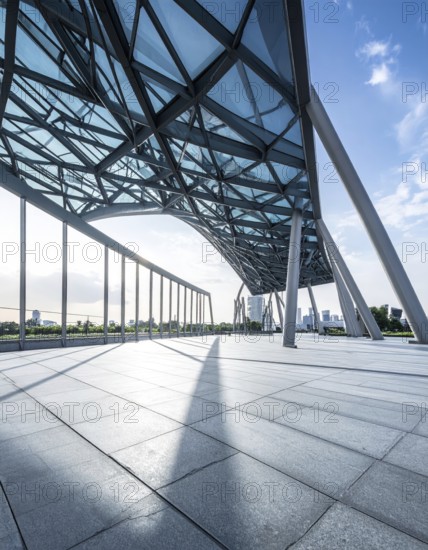 Modern architectural framework with glass and steel structure, glass facade with a greed of steel arrows, blue sky with a soft golden light of a sunrise, AI generated