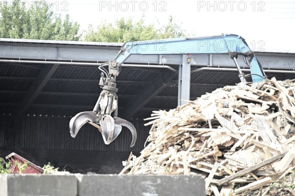 Loading crane with grab arm for loading wood waste for wood pellet production on the premises of Energie-Mann in the Westerwald. manufactured
