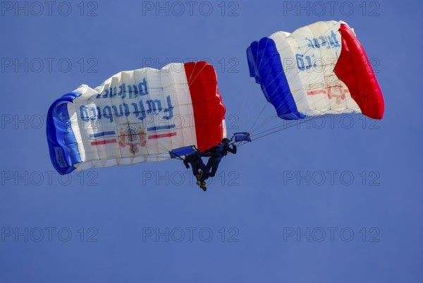 Two parachutists during an aerial acrobatic performance as part of an air show at the Rossfeld in Metzingen-Glems, Baden-Württemberg, Germany, for editorial use only