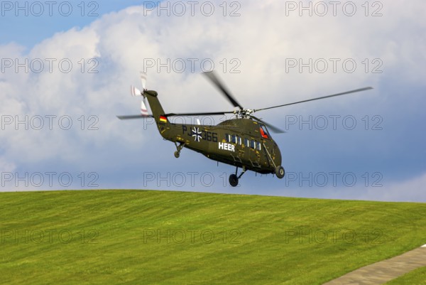 A Sikorsky S-58C transport helicopter in the colours of the German Army with the registration D-HAUG during a flight demonstration as part of an air show at the Rossfeld in Metzingen-Glems, Baden-Württemberg, Germany, for editorial use only