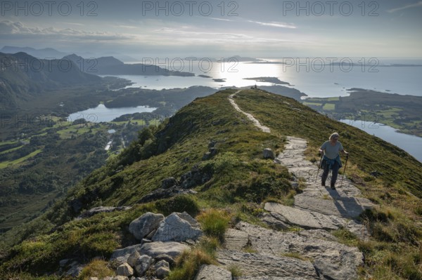 Woman with hiking poles walking up Rørsethornet stone stairs, with 3292 steps one of the longest continuous stone stairs in the world, Sherpat stairs or Midsund stairs or Midsundtrappene, Rørsethornet hike, Otroya or Otrøya island, Møre og Romsdal, Norway