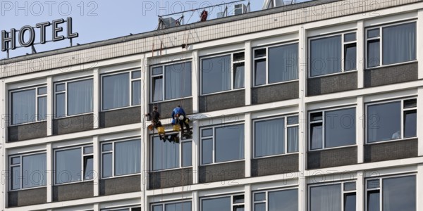 Two male glass cleaners abseiling down the hotel façade to clean windows, aletto Hotel Kudamm, Berlin, Germany