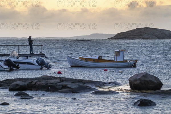 Small bay, archipelago, jetty with angler, Resö Island, Bohuslän, Skagerrak, Sotenäs, Västra Götalands län, Sweden