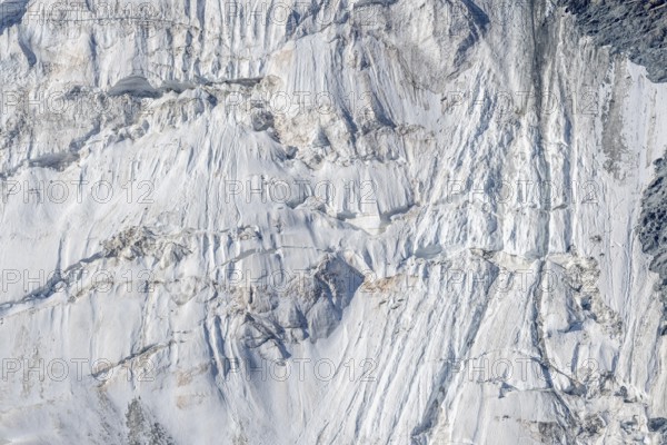 Intricate patterns of ice and rock are showcased in this stunning glacial landscape, revealing the effects of time on the frozen surface. The bright daylight emphasises the textures and colours. Gorner Glacier, Zermatt, Valais, Alps, Swiss