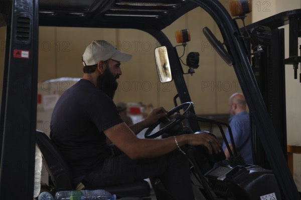 Relief workers unload boxes of medical aid provided by Qatar at Damascus International Airport, part of the humanitarian bridge supporting Syria's recovery and reconstruction after the fall of Bashar al-Assad, Damascus, Damascus, Syria