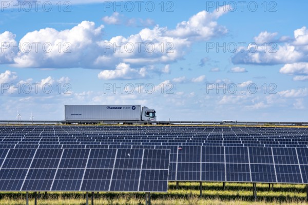 86, 5 MW peak ground-mounted photovoltaic systems, by RWE, with over 141, 000 solar modules, on a verge, over 1 km long, along the A44 motorway near Bedburg, at the Jackerath junction, recultivated open-cast mining site, field with sunflowers, North Rhine-Westphalia, Germany