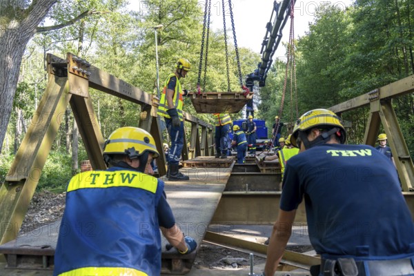 Construction of a temporary bridge over a slipped road crossing a stream, by the bridge construction section of the THW, 18 metre long steel bridge of the Krupp-D type, is assembled in around 8 hours, large-scale exercise FÜLEX25 lasting several days, of the THW North Rhine-Westphalia regional association, over 3500 volunteers from the 127 North Rhine-Westphalia local associations practise on 4 weekends, many different deployment scenarios