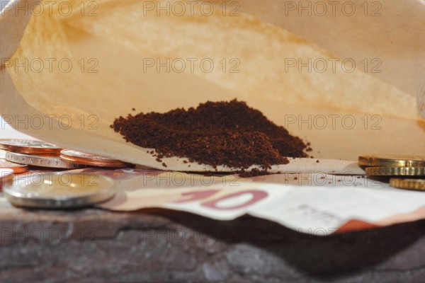 Ground coffee in a filter bag with coins and a ten euro note in front of it, North Rhine-Westphalia, Germany